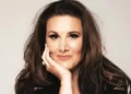 Sam Bailey Sam Bailey looking at the camera with her hand on her chin.