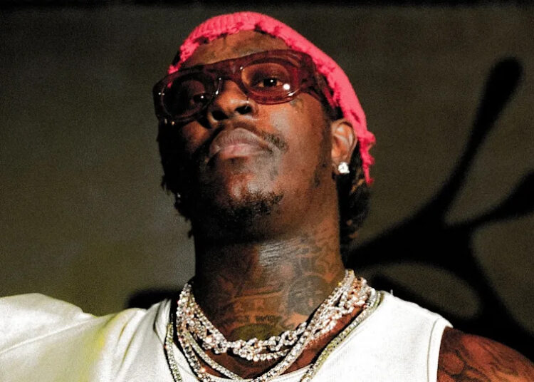 Young Thug in a white tank top with chains and sunglasses