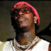 Young Thug in a white tank top with chains and sunglasses