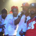 Cam'ron, Jim Jones, Juelz Santana, and Freekey Zekey on stage, wearing casual and urban-style clothes, with baseball caps and jewelry, posing for a photo