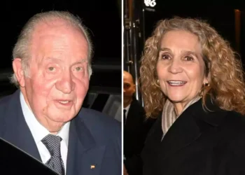 Juan Carlos I and Infanta Elena, a man and a woman, pose smiling at a nighttime event.