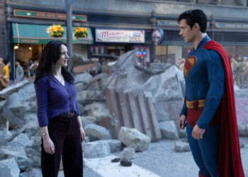 Lois Lane and Superman stand amidst urban rubble, engaging in conversation