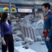 Lois Lane and Superman stand amidst urban rubble, engaging in conversation