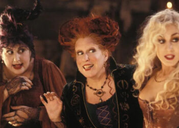Kathy Najimy, Bette Midler, and Sarah Jessica Parker as the Sanderson sisters stand side-by-side in Hocus Pocus