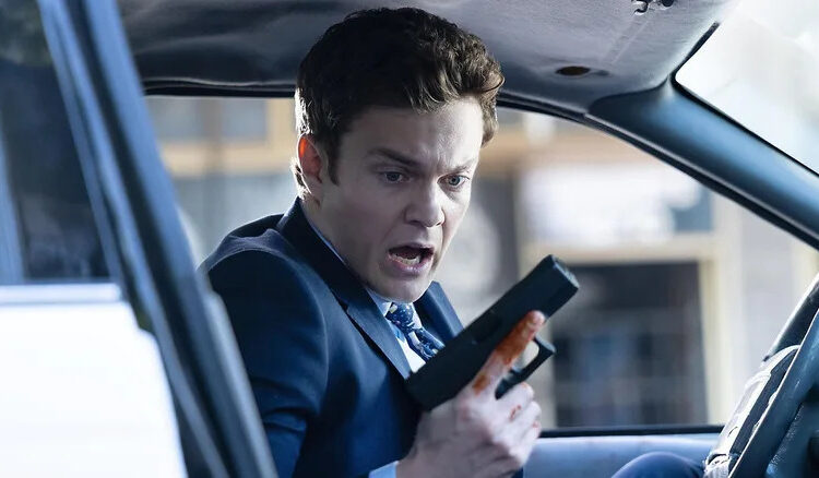 Nathan looking at his hand holding a gun in "Novocaine" (2025)