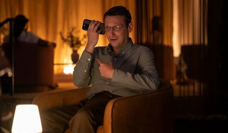 Ron on the phone pointing and making a weird face on The Chair Company