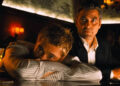 Rusty with his head in his arms at a bar top with Danny next to him in Ocean's Eleven
