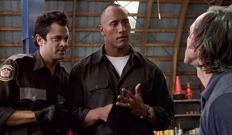 Ray and Chris talking to a bad guy in a warehouse in Walking Tall