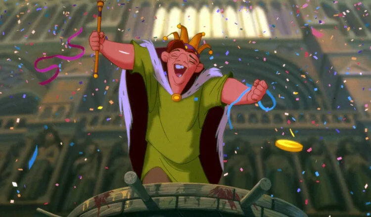 Quasimodo celebrates with a crown and staff in The Hunchback of Notre Dame