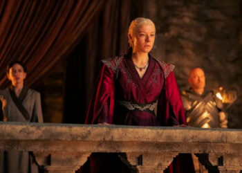 Rhaenyra watching in horror from a balcony dressed in royal robes on House of the Dragon