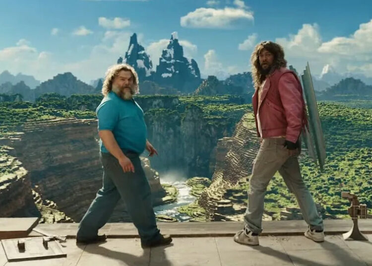 Jack Black and Jason Momoa both turn around to look back from the edge of a cliff in A Minecraft movie