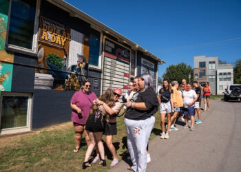 Ashton Kelley (in the sunglasses) hugs a fellow Swiftie in front of Grimey's record store in East Nashville. Kelley brought dozens of Swifties together for a Taylor Swift retreat. Oct. 5, 2025.
