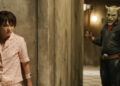 Madeleine McGraw as Gwen hiding behind a wall from Ethan Hawke as The Grabber in Black Phone 2