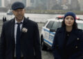 Danny Reagan and Maria Baez next to a cop car "Blue Bloods"
