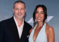 Brad Pitt and girlfriend Ines de Ramon smile and pose together on the red carpt at the F1 premiere.