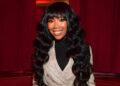 Brandy smiles wearing grey coat