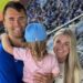 Charlie Kirk smiling with his family at a baseball game, remembered after his fatal shooting sparked country music tributes.