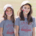 Two girls wearing white baseball caps and gray Crane t-shirts, show off their face paintings that are always a hit at the Crane Country Fair. (Courtesy photo)