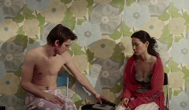 Josh Hartnett as Slevin Kelevra and Lucy Liu as Lindsey sitting by the phone and staring at it in Lucky Number Slevin