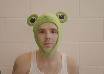 Cruz Beckham, 20, stripped off into a vest and a quirky frog hat as he released a new video for his single Lick The Toad