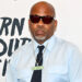 Damon Dash wearing sunglasses, a light blue shirt, and a necklace with
