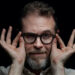 CEO Sam Reich of Dropout takes hold of his glasses