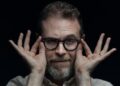 CEO Sam Reich of Dropout takes hold of his glasses