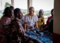Duchess Sophie looking at a piece of blue fabric with a group of women in Congo wearing traditional garments
