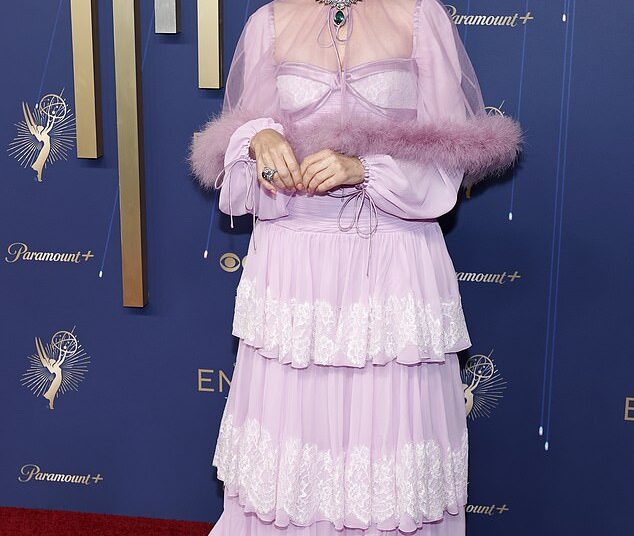 Renowned actress Parker Posey, 56, who most recently appeared in The White Lotus, arrived in an old fashioned frilly, tiered lilac gown that featured long sleeves and a sheer mini cape with a fur hem