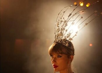 a person wearing an elaborate headpiece and jewelry set against a dramatic background