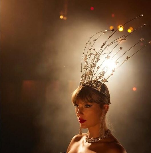 a person wearing an elaborate headpiece and jewelry set against a dramatic background