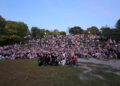 P1Harmony take a group photo with hundreds of fans during a fan meeting at Trinity Bellwoods Park.