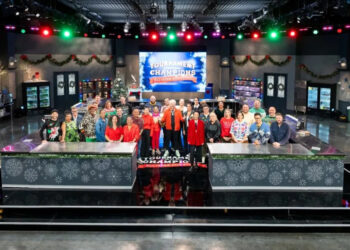Host Guy Fieri with contestants Adam Sobel, Christian Petroni, Mei Lin, Nini Nguyen, Amanda Freitag, Aaron Sanchez, Jet Tila, Ashley Holt, Alex Guarnaschelli, Antonia Lofaso, Aarti Sequeira, Crista Luedtke, Jonathan Sawyer, Zac Young, Britt Rescigno, Sara Bradley, Damaris Phillips, Michael Voltaggio, Bryan Voltaggio, Maneet Chauhan, Stephanie Izard, Kevin Lee, Dale Talde, Shirley Chung, Sherry Yard, Marcel Vigneron, Tobias Dorzon, Marcus Samuelsson, Rachel Sherriffe, Graham Elliot, and Giuseppe Tentori, as seen on Tournament of Champions Holiday, Season 1.