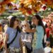 A photo of two women in a gazebo with fall decor strung up on the structure.