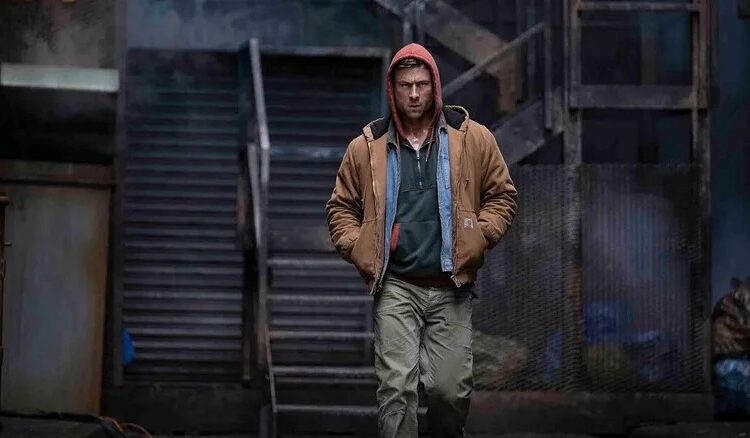 Glen Powell as Ben Richards walking and wearing a hoodie in The Running Man (2025)