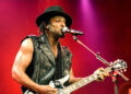 D'Angelo plays the guitar on stage.