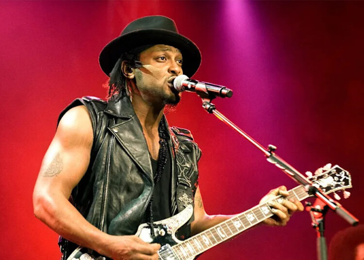 D'Angelo plays the guitar on stage.