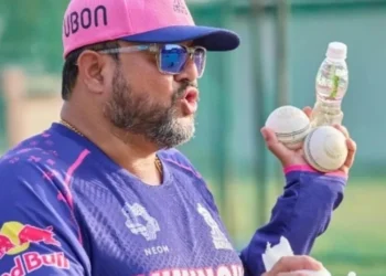 Siddhartha Lahiri, Rajasthan Royals coach, holding cricket balls and a water bottle during a training session.