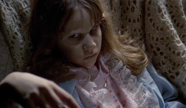 A possessed Regan lying down in The Exorcist
