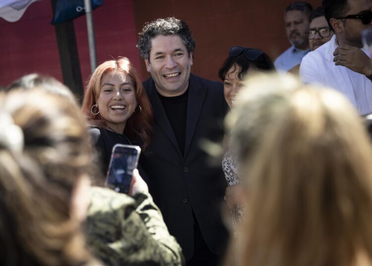 Conductor Gustavo Dudamel poses for pictures during block party