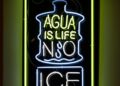 Neon art that reads "Agua Is Life No Ice."
