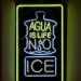 Neon art that reads "Agua Is Life No Ice."