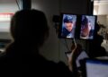 A person looks at dual vertical monitors during a scene of a film