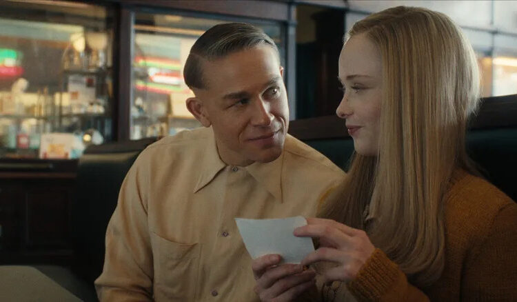 Charlie Hunnam as Ed Gein seated next to Suzanna Son as Adelina in a diner booth in Monster: The Ed Gein Story