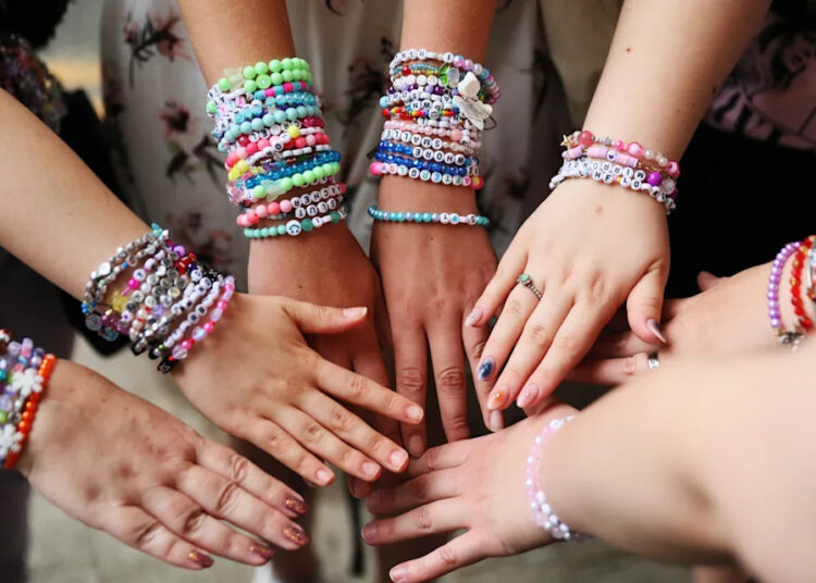 Taylor Swift fans show off friendship bracelets.