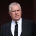 A medium shot of Prince Andrew wearing a black suit and tie
