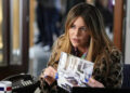 Kaitlin Olson as Morgan Gillory holding up a crime scene photo in High Potential