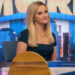 Reese Witherspoon sitting at the desk of The Morning Show.