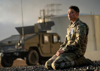 A soldier cries on the ground.