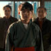 Ben Wang's Li Fong standing in the middle with Ralph Macchio and Jackie Chan behind him with NYC behind them in Karate Kid: Legends.